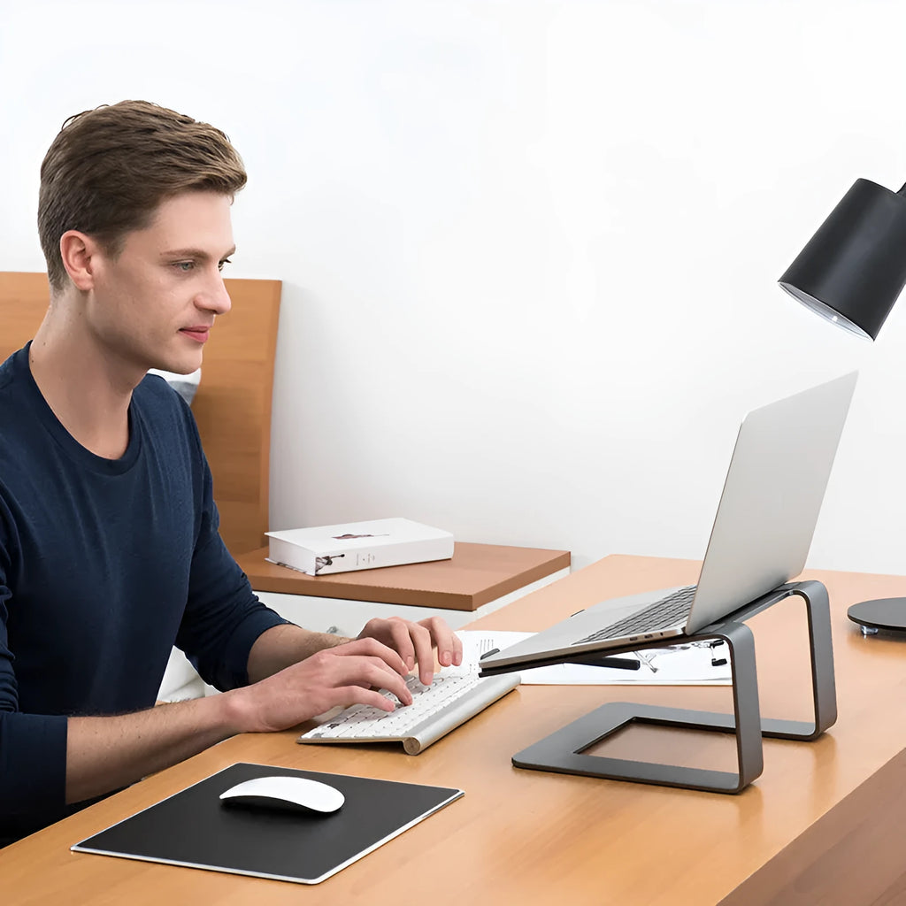 Black aluminium alloy laptop stand folded on desk next to silver version