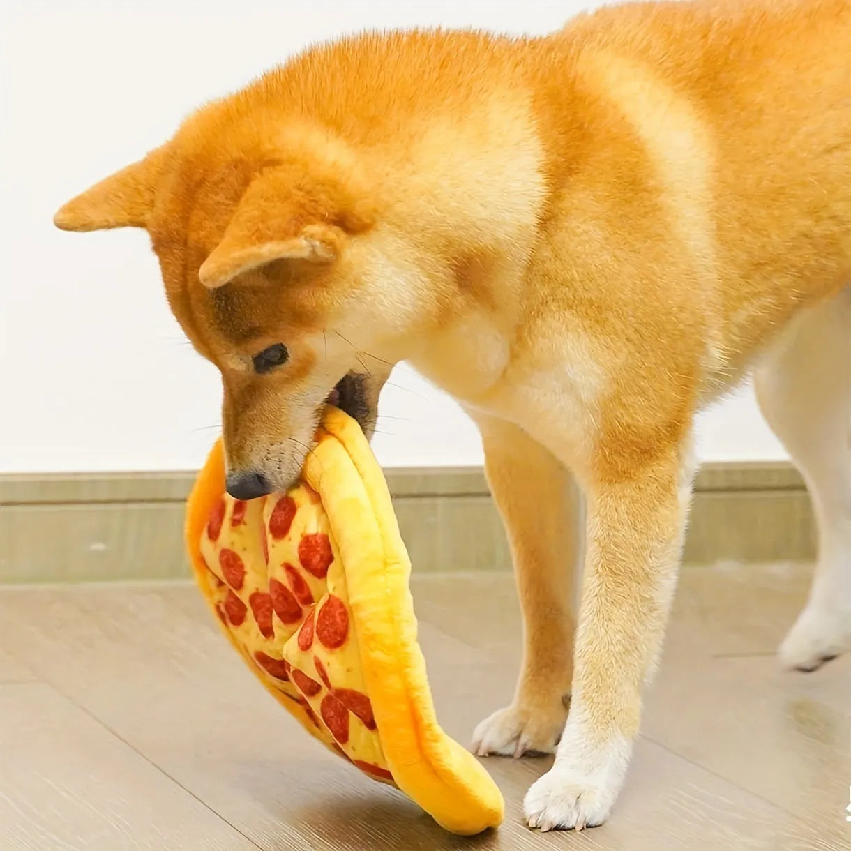 Yellow pizza slice squeaky plush dog chewing toy on white background