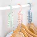 Blue revolving plastic wardrobe hanger with five hooks and a central handle for rotating.