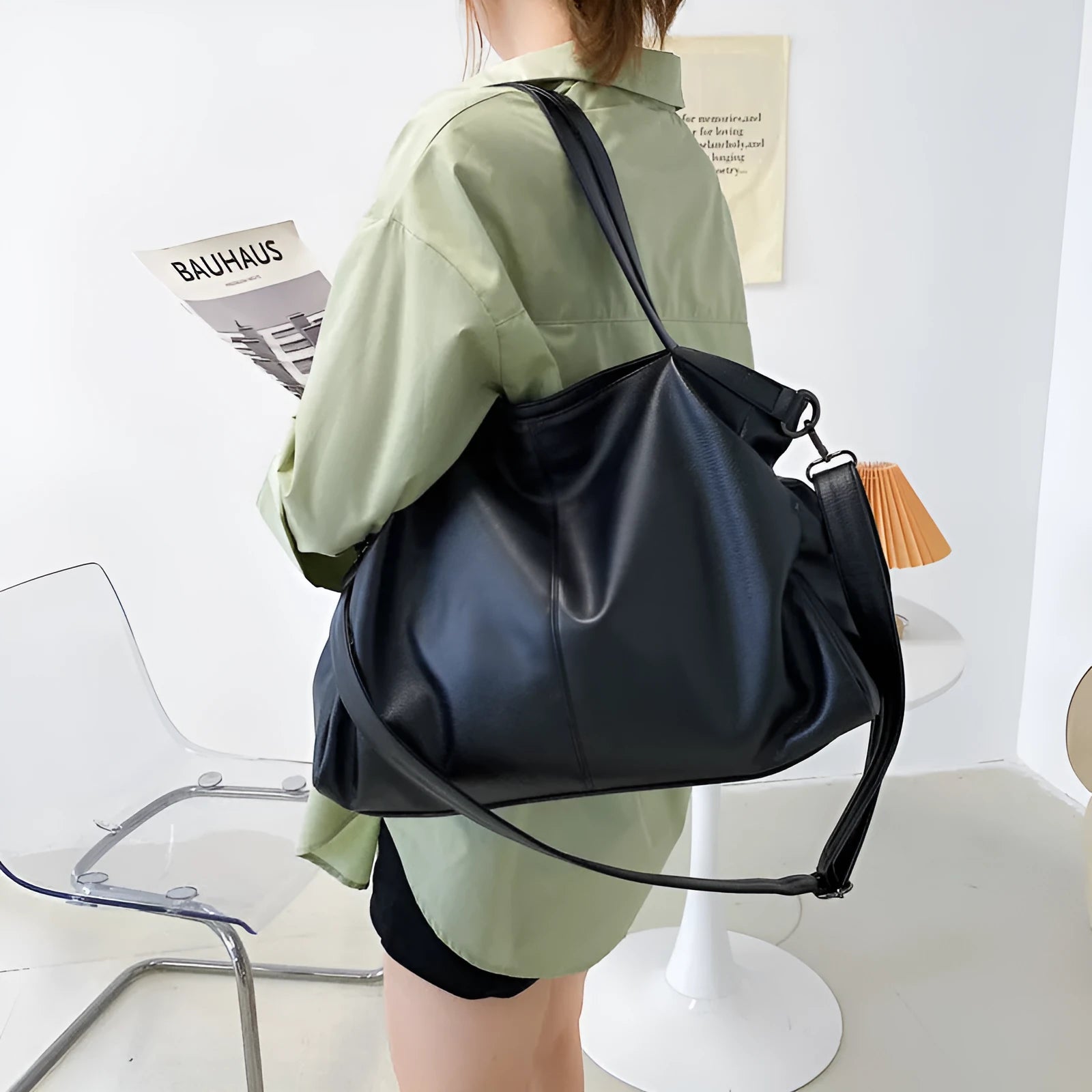 Large soft black PU leather messenger tote bag with a shoulder strap, showing zipper and phone pocket.