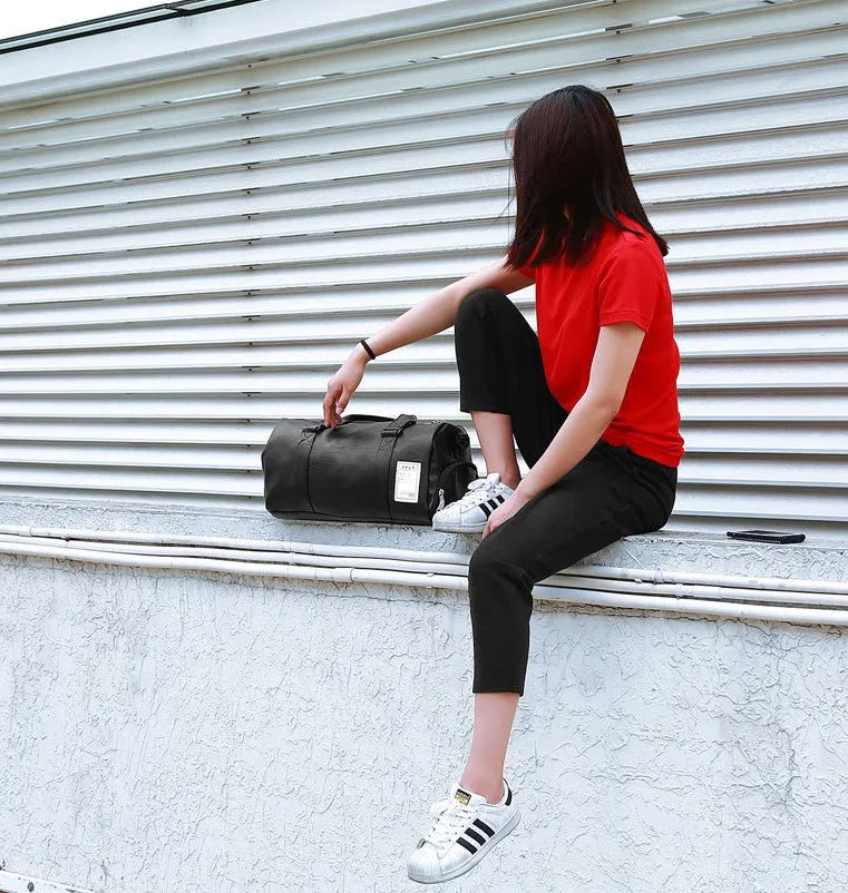 Large black waterproof sports gym bag with separate side shoe compartments and a diagonal carry strap.