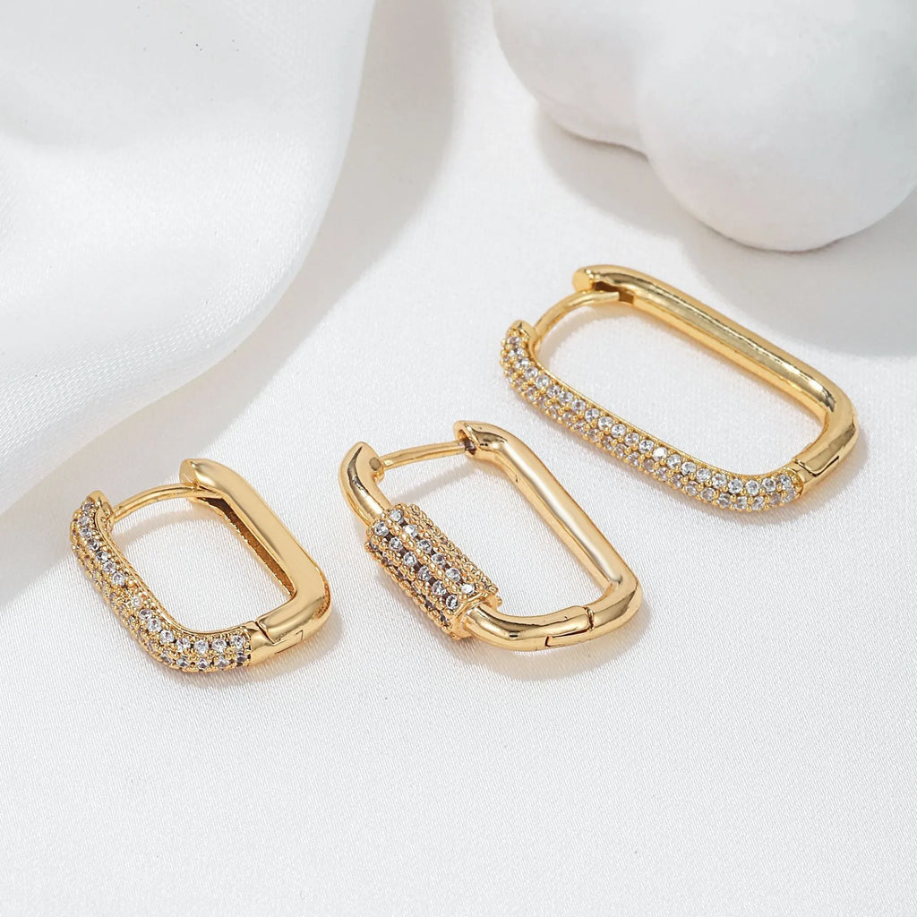 Three geometric square ear clips with inlaid zircon stones in gold and white gold colours
