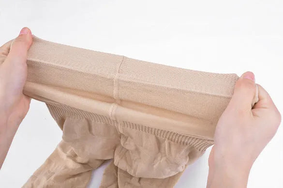 Black seamless high waist shapewear shorts for women laid flat, showing tummy control panel.