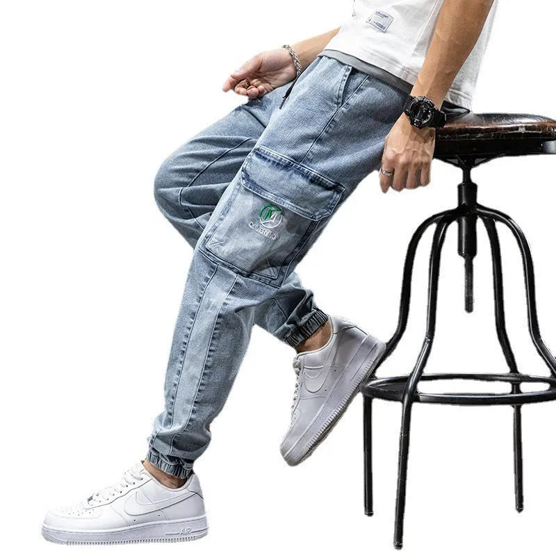 Men's loose fit blue cargo jeans with straight leg and cargo pockets on a plain background.