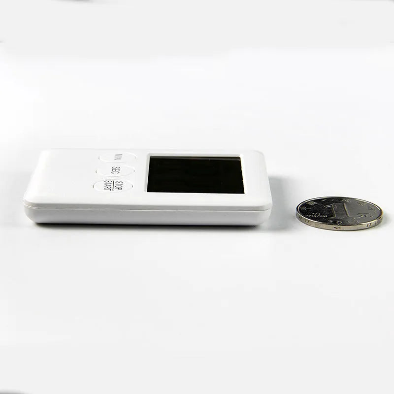 Black and white kitchen timer with magnet back for refrigerator mounting.