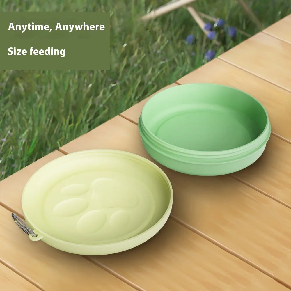 Collapsible portable silicone dog bowl in light green, shown with carrying strap.