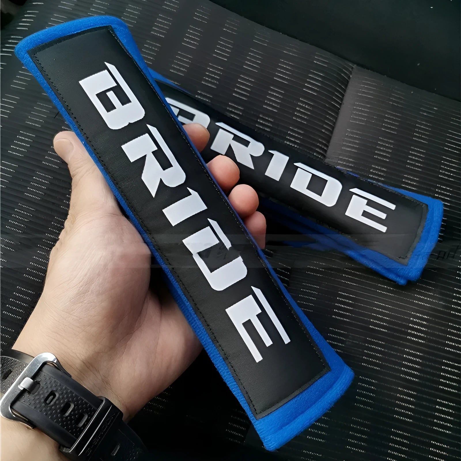 Car seatbelt shoulder pads in black, blue, and red colours showing cotton and sponge cloth embroidery weave construction