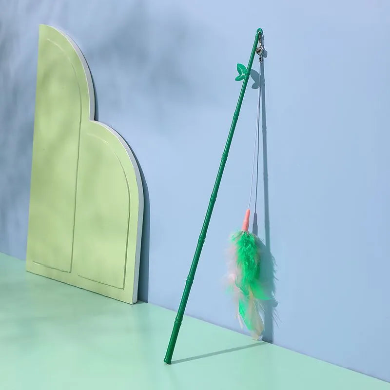 Green interactive cat wand toy with feathers and a bell on a durable plastic handle.