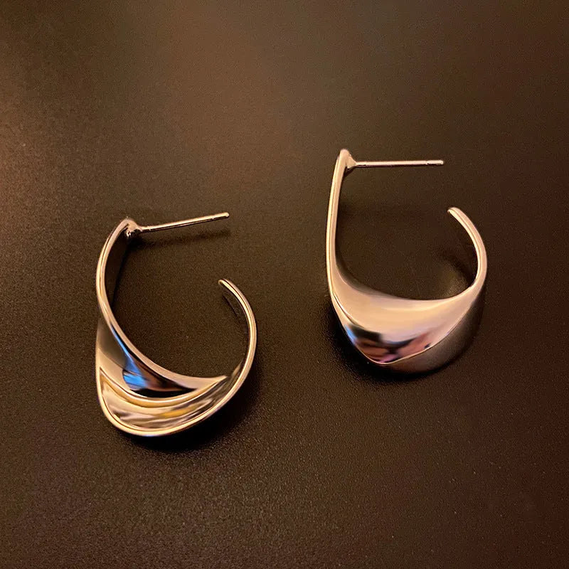 Geometric round metal earrings with twisted design in gold electroplated finish
