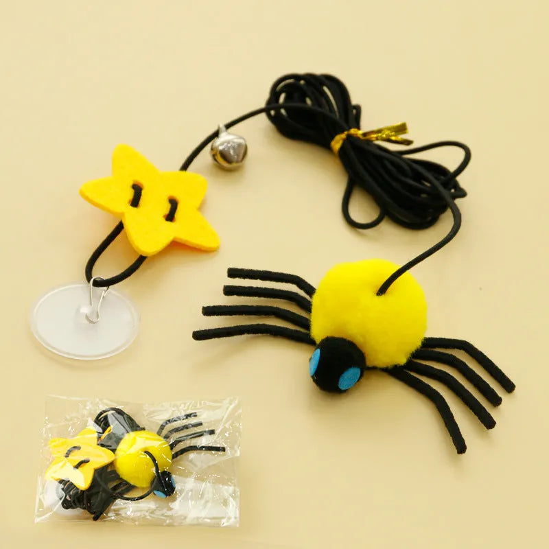 Cat hanging door toy with elastic rope, feather, bell and spider attachment on a white door.