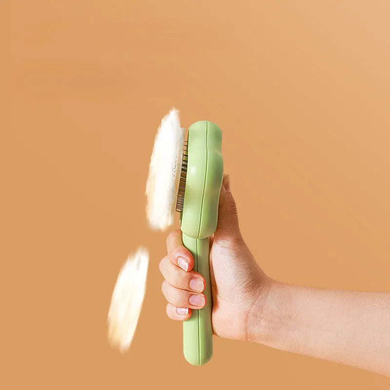 Green handle self-cleaning stainless steel needle comb for cats on a white background