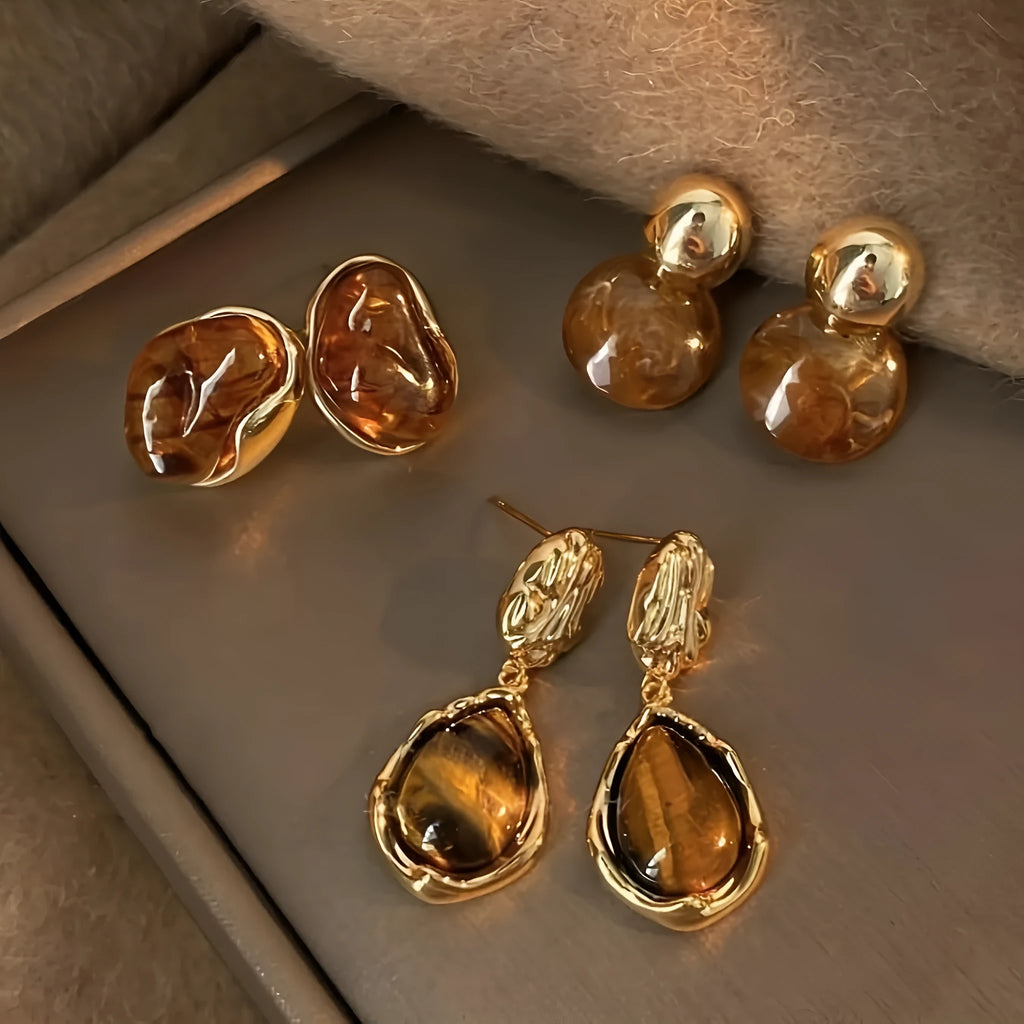 Three pairs of geometric holiday earrings with tassel accents in electroplated alloy
