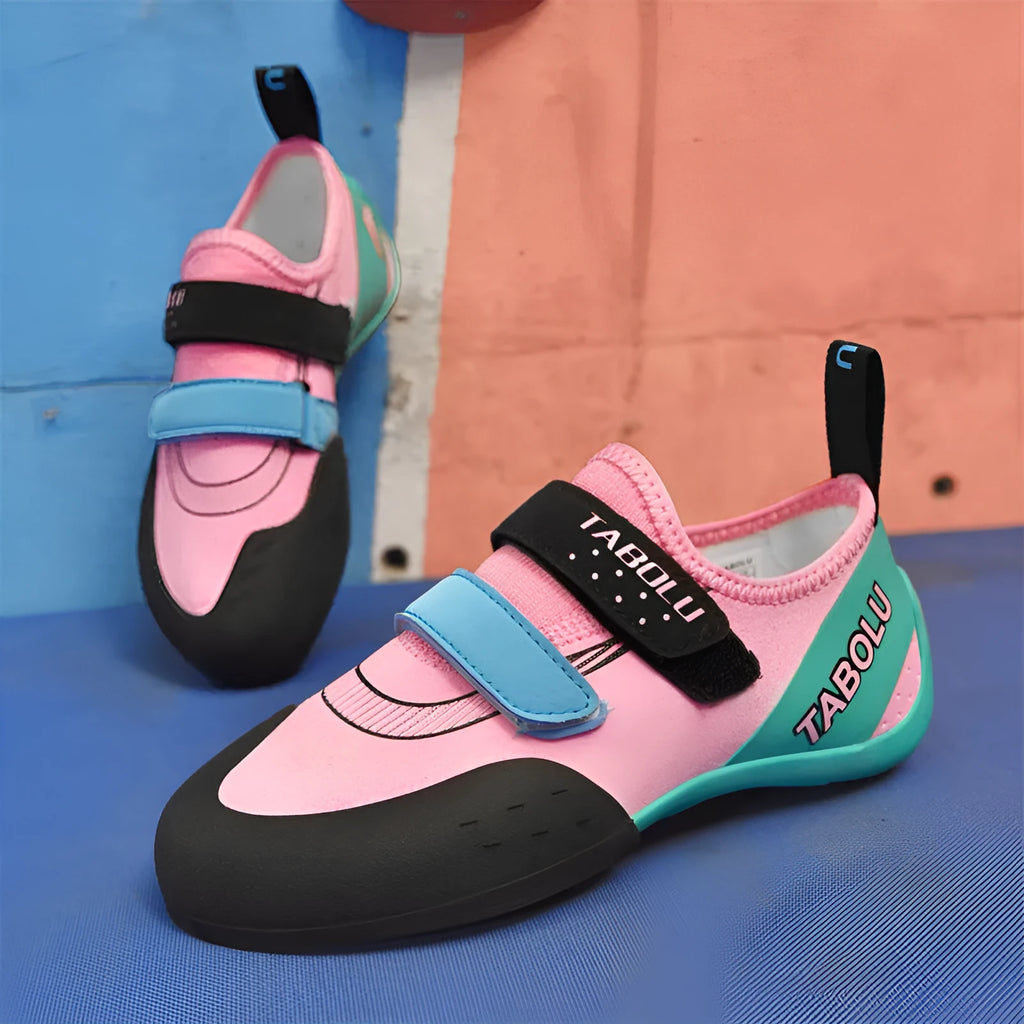 Beginner rock climbing shoes with Velcro strap and rubber sole in black and red colour combination
