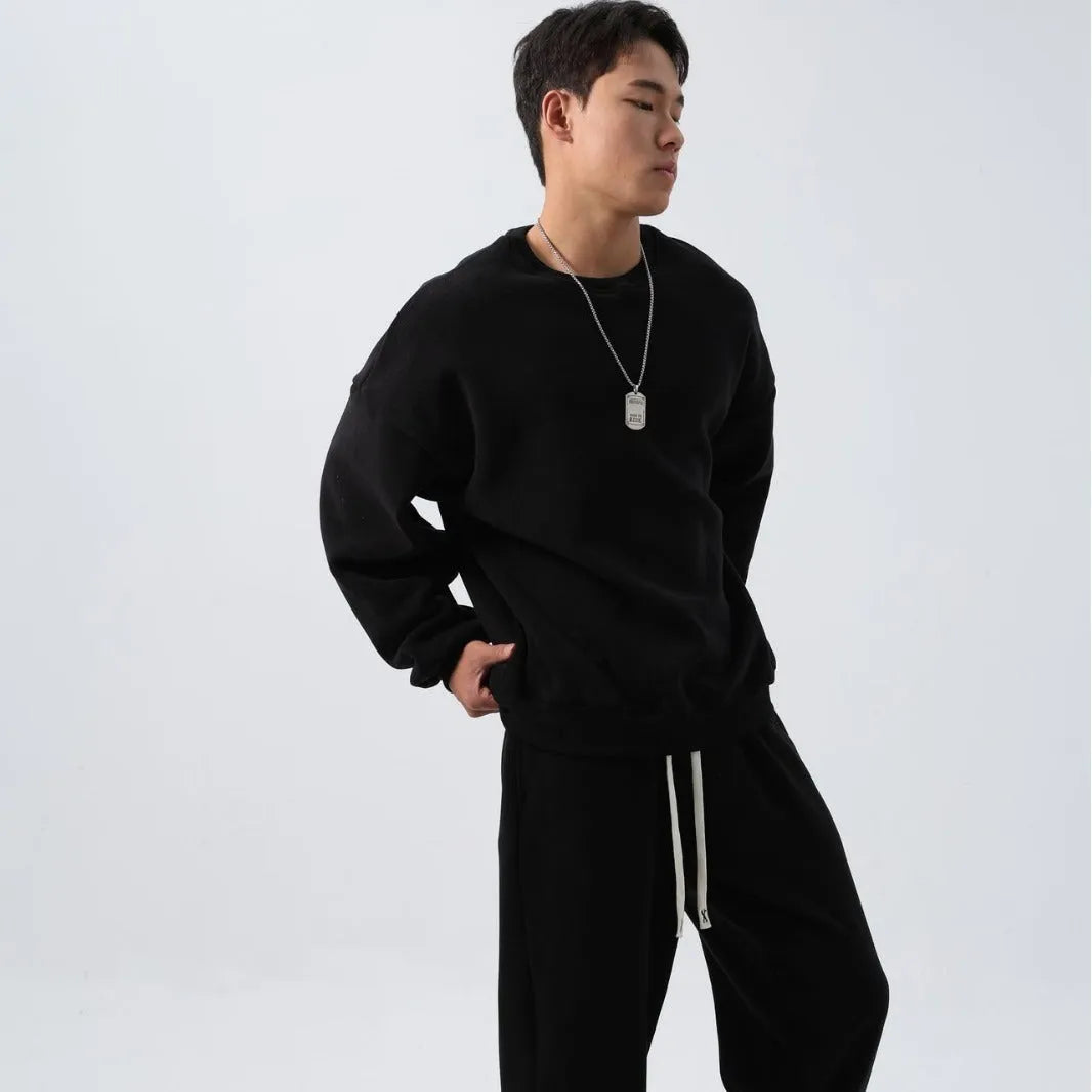 Men's black polar fleece sports suit with long sleeve crew neck coat and loose fit trousers.