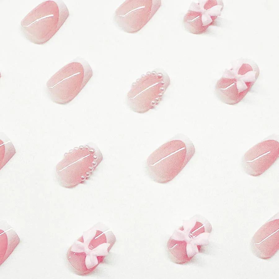 Artificial fashion nail set with white French tips, bow designs, and multiple patterns including tulip and starry sky