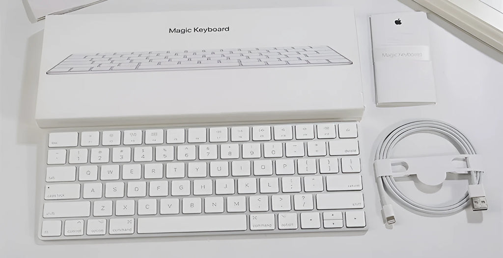 White Apple Bluetooth G6 wireless keyboard with multimedia keys in a metal box.