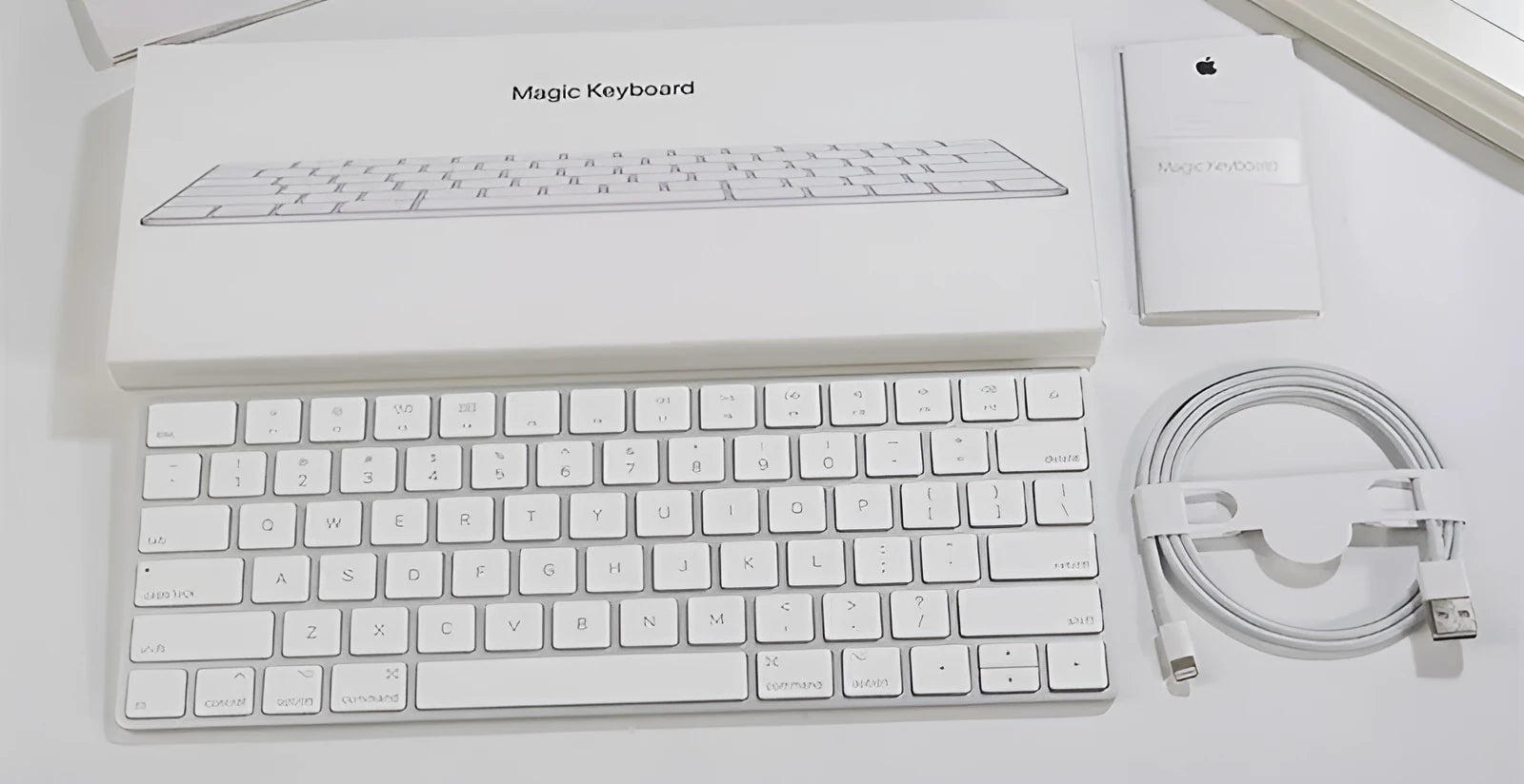 White Apple Bluetooth G6 wireless keyboard with multimedia keys in a metal box.