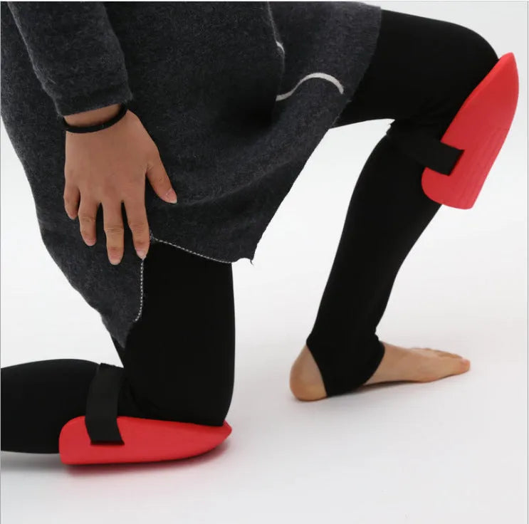 A pair of black EVA foam knee pads for gardening, shown from above on a hard surface.