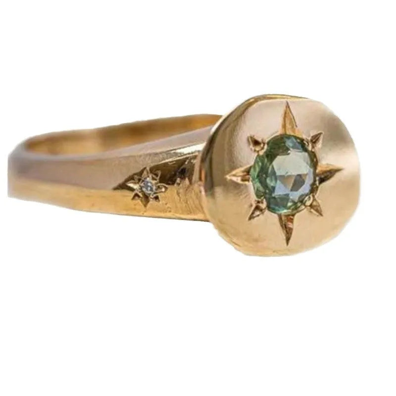 Golden oval asterism star ring with zircon stones and an adjustable opening.