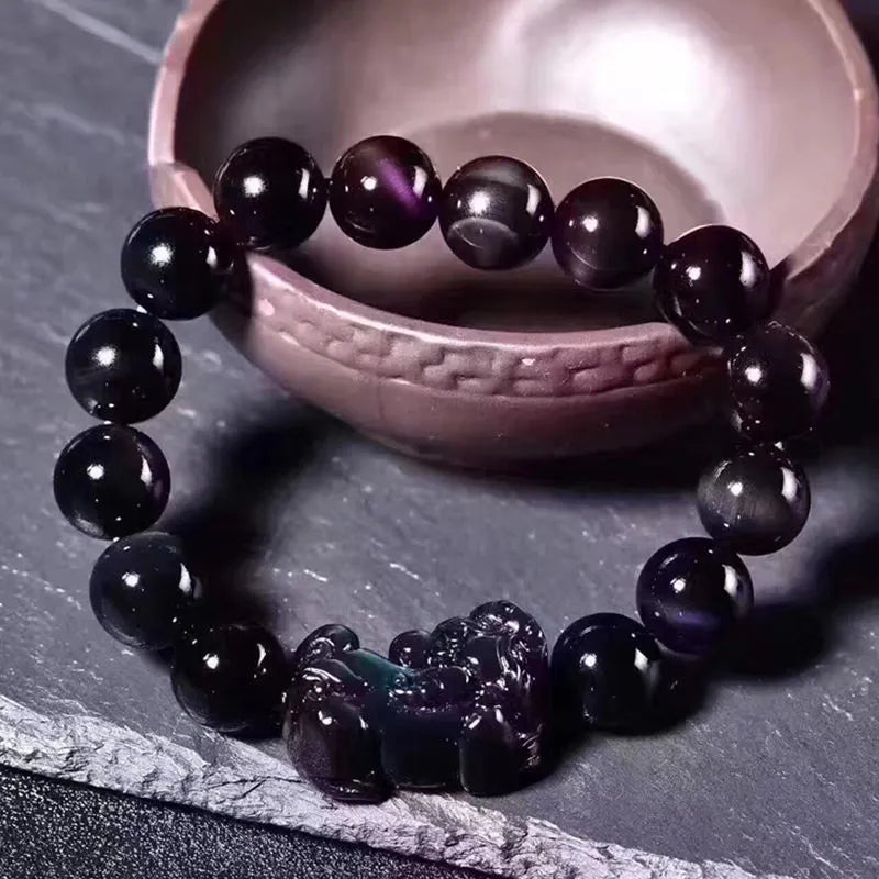 Natural ice colour obsidian crystal bracelet with spherical beads on a wrist.