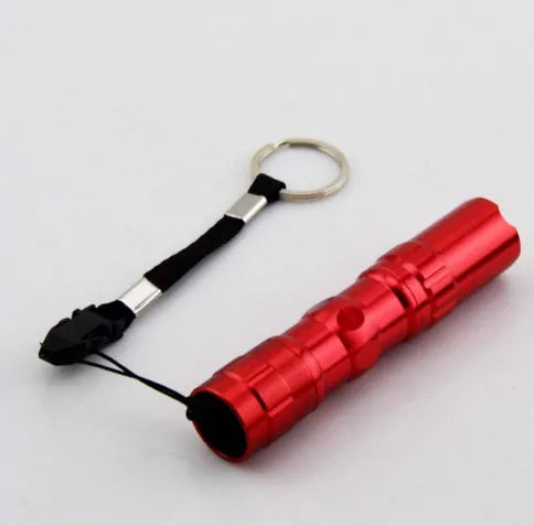 Compact black aluminium LED mini flashlight showing scale against a hand