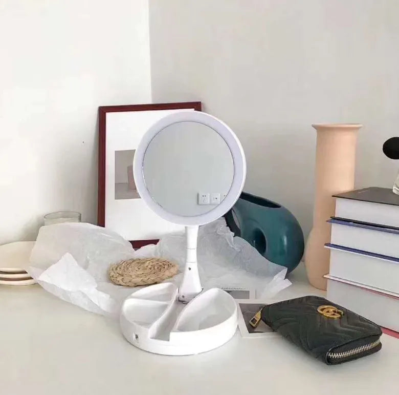 White acrylic double-sided vanity mirror with LED lights and a foldable stand.