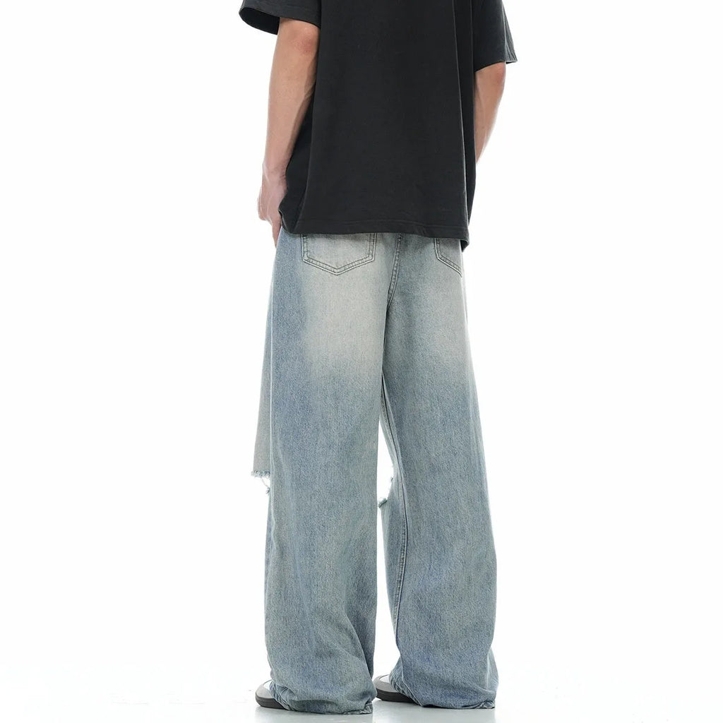Men's blue straight-leg jeans with ripped details on the legs, showing a zipper fly.