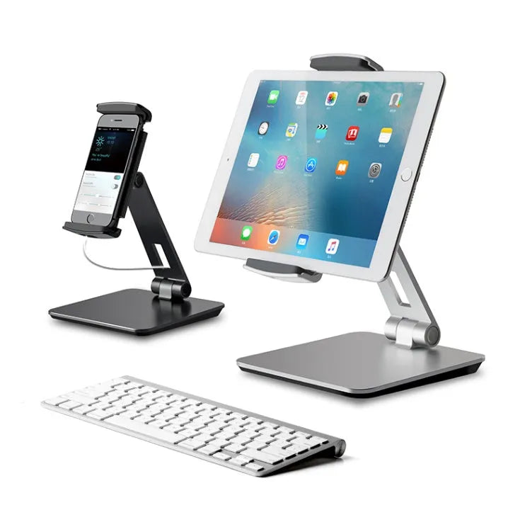Black foldable aluminium phone and tablet stand with 360-degree rotation on a wooden desk