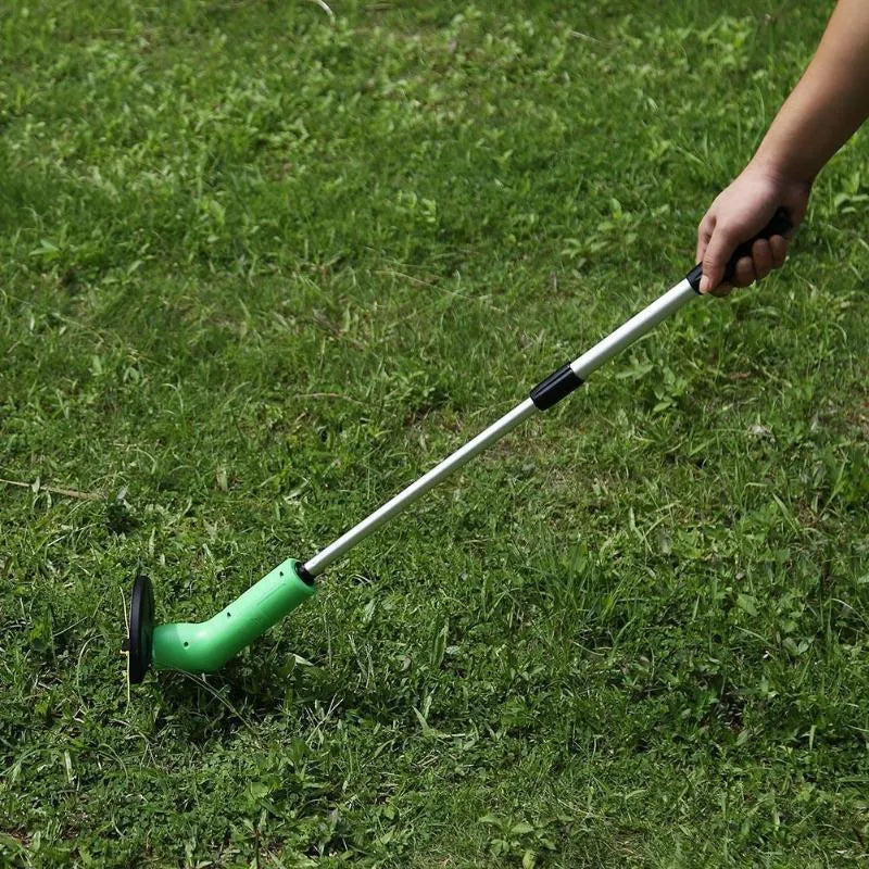 Cordless lawn trimmer with extension pole and protective shield on grass