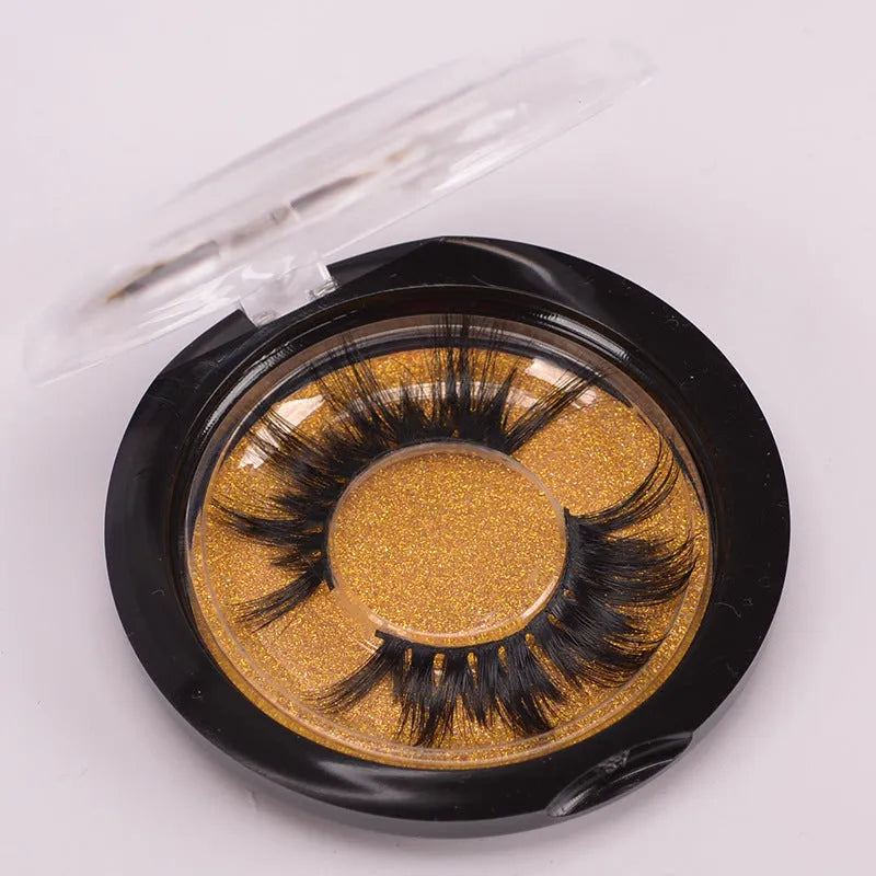 5D mink false eyelashes in natural black with curled ends, shown with double-headed glue brush and hair cap
