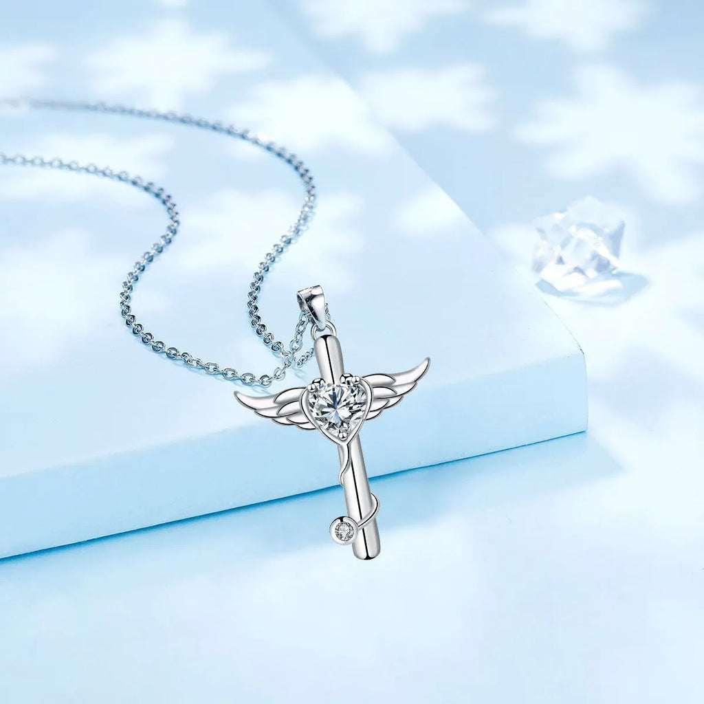 Close-up of a women's necklace featuring a combined cross and stethoscope pendant with wings detail in a red diamond finish.