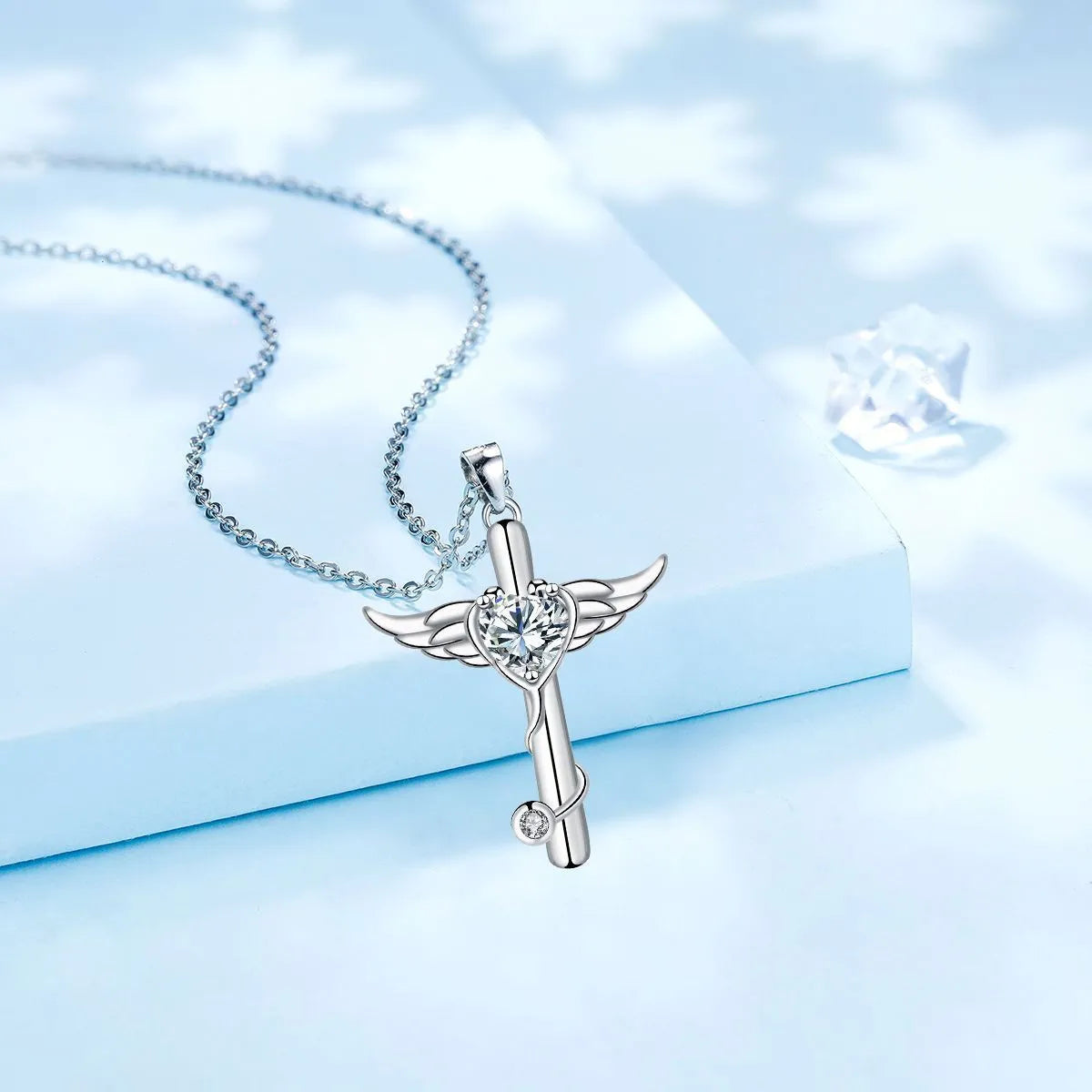 Close-up of a women's necklace featuring a combined cross and stethoscope pendant with wings detail in a red diamond finish.