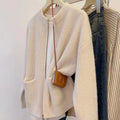 Beige viscose fibre sweater coat cardigan with long sleeves laid flat.