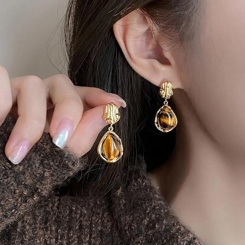 Three pairs of geometric holiday earrings with tassel accents in electroplated alloy