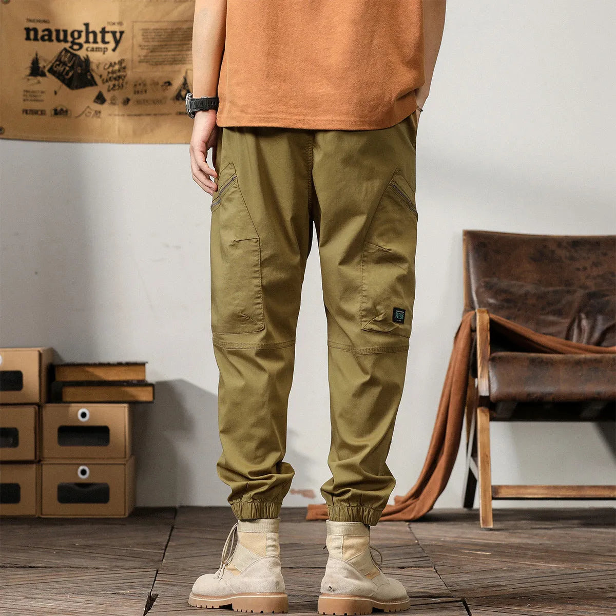 Men's loose cotton harem pants in khaki with a tapered ankle opening and zip fly.