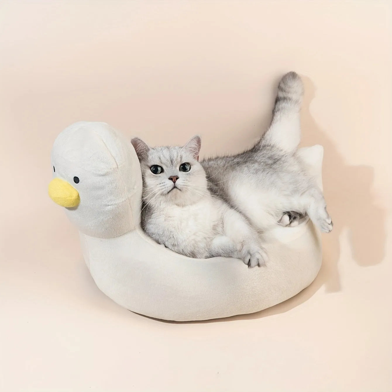 Blue duck-shaped fluffy pet bed for a small dog on a wooden floor.