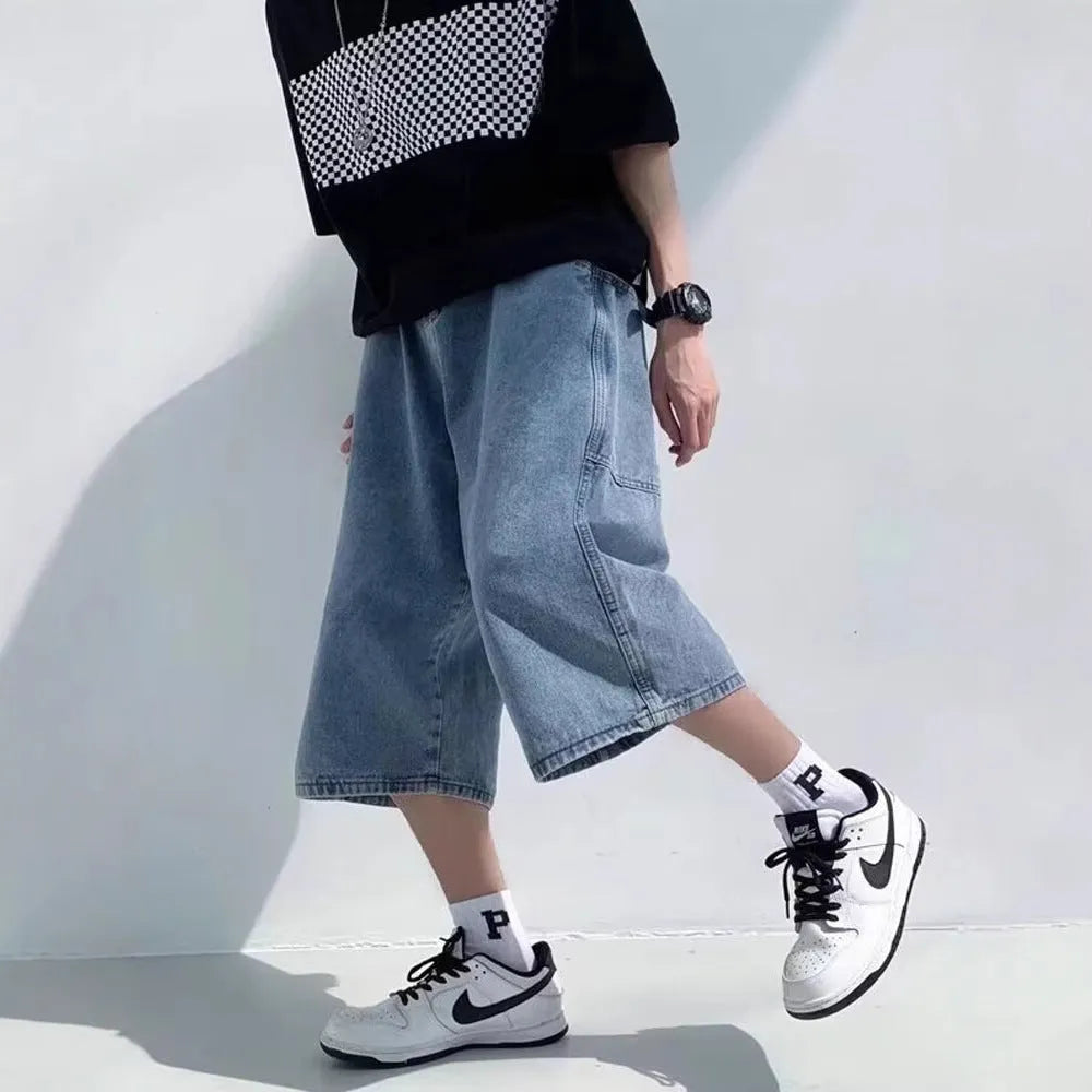 Man wearing blue high-waist straight-leg denim pirate shorts, showing cropped length and zipper fly