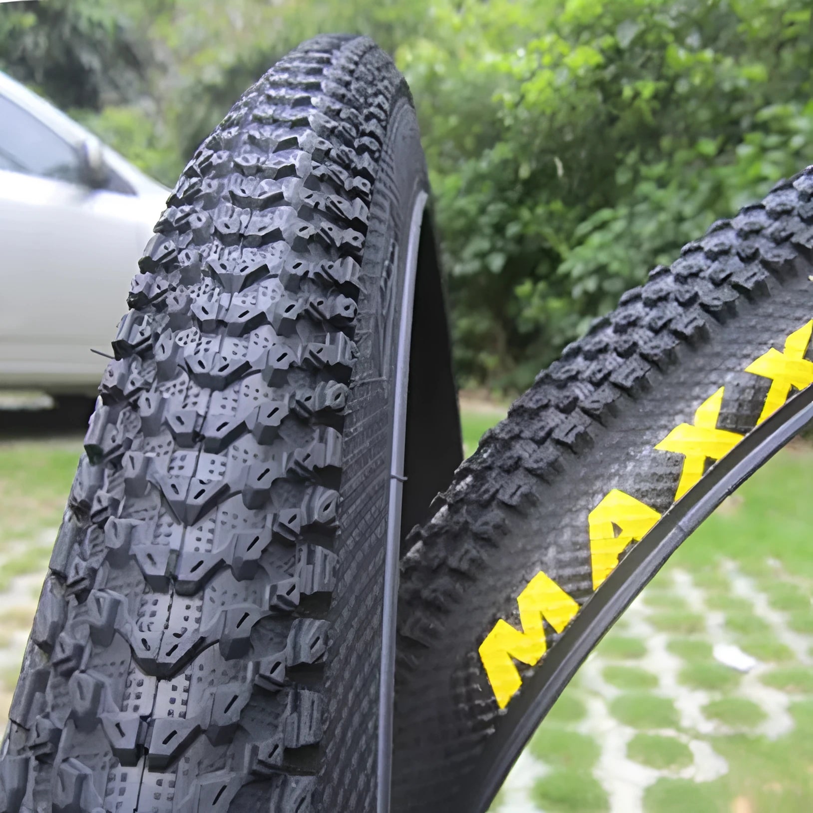Ultralight black mountain bike tyre with white label sidewall option on a trail.