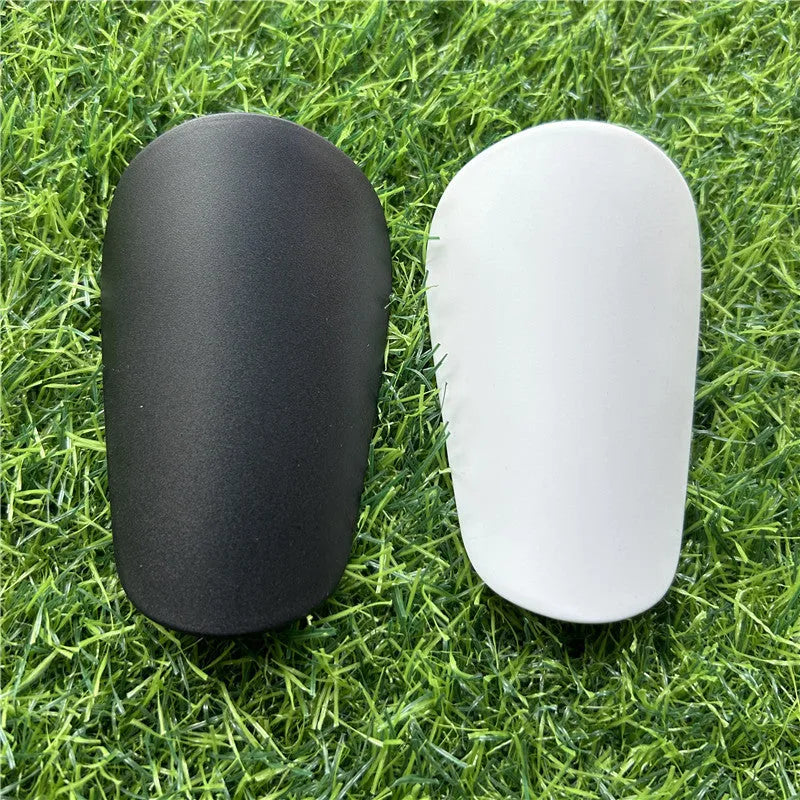 Extra small plastic football shin guards measuring 8x5cm in black and white for youth players