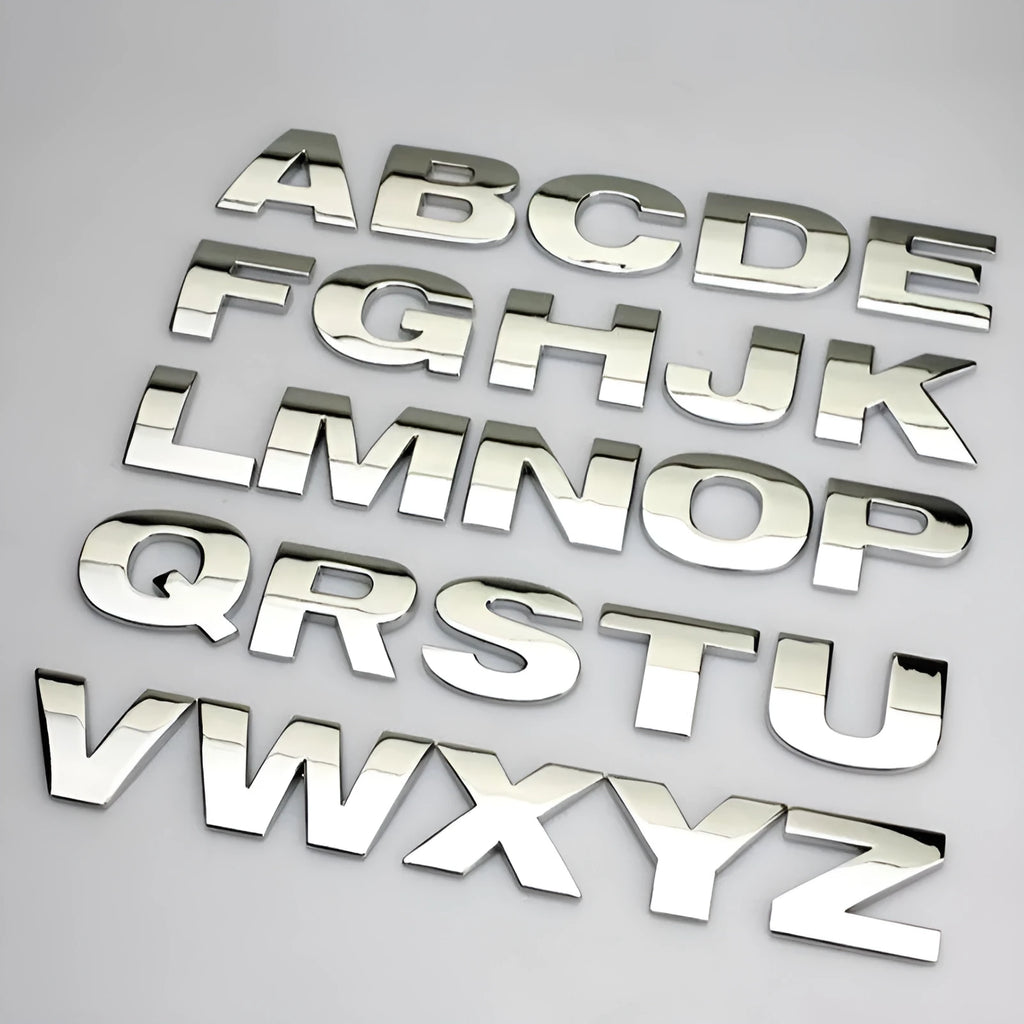 Close-up of a silver metal zinc alloy 3D letter 'A' car bumper sticker, approximately 2.5cm in size.