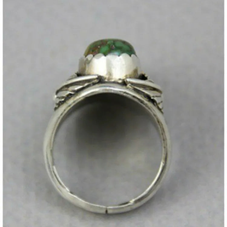 Close-up of a women's geometric retro ring with an inlaid turquoise stone on an alloy band.