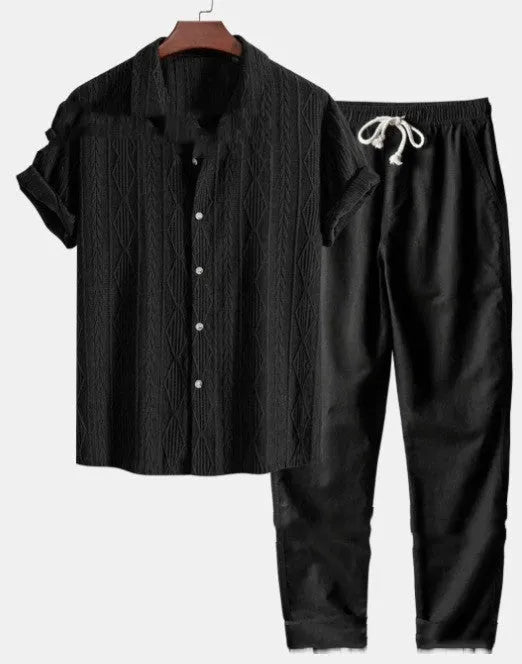 Man wearing a loose fit short sleeve shirt and matching trousers from a milk silk polyester summer suit set.