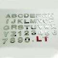 Close-up of a silver metal zinc alloy 3D letter 'A' car bumper sticker, approximately 2.5cm in size.