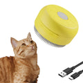 Rechargeable silicone steam brush for cats and dogs in green or yellow with ergonomic handle for removing loose hair.