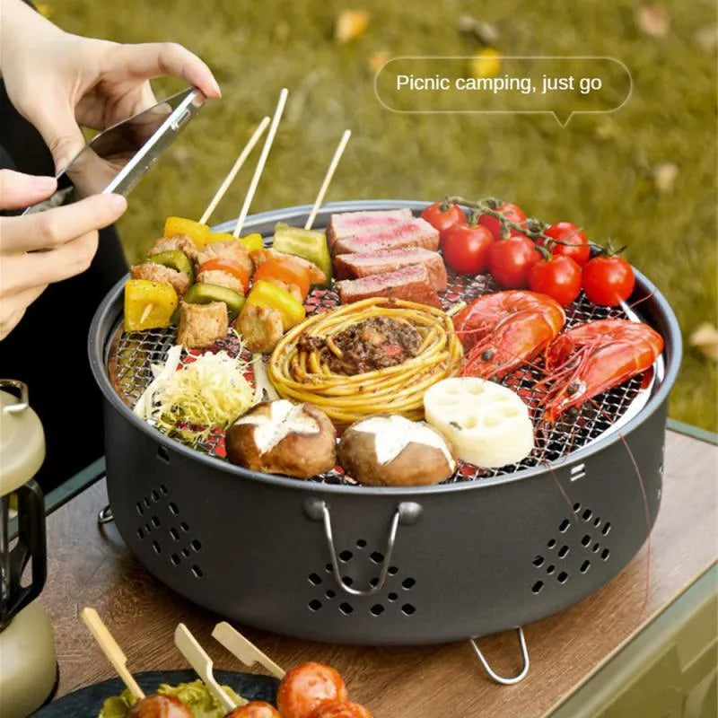 Portable stainless steel charcoal BBQ grill with detachable parts and a carry bag, shown in grey.