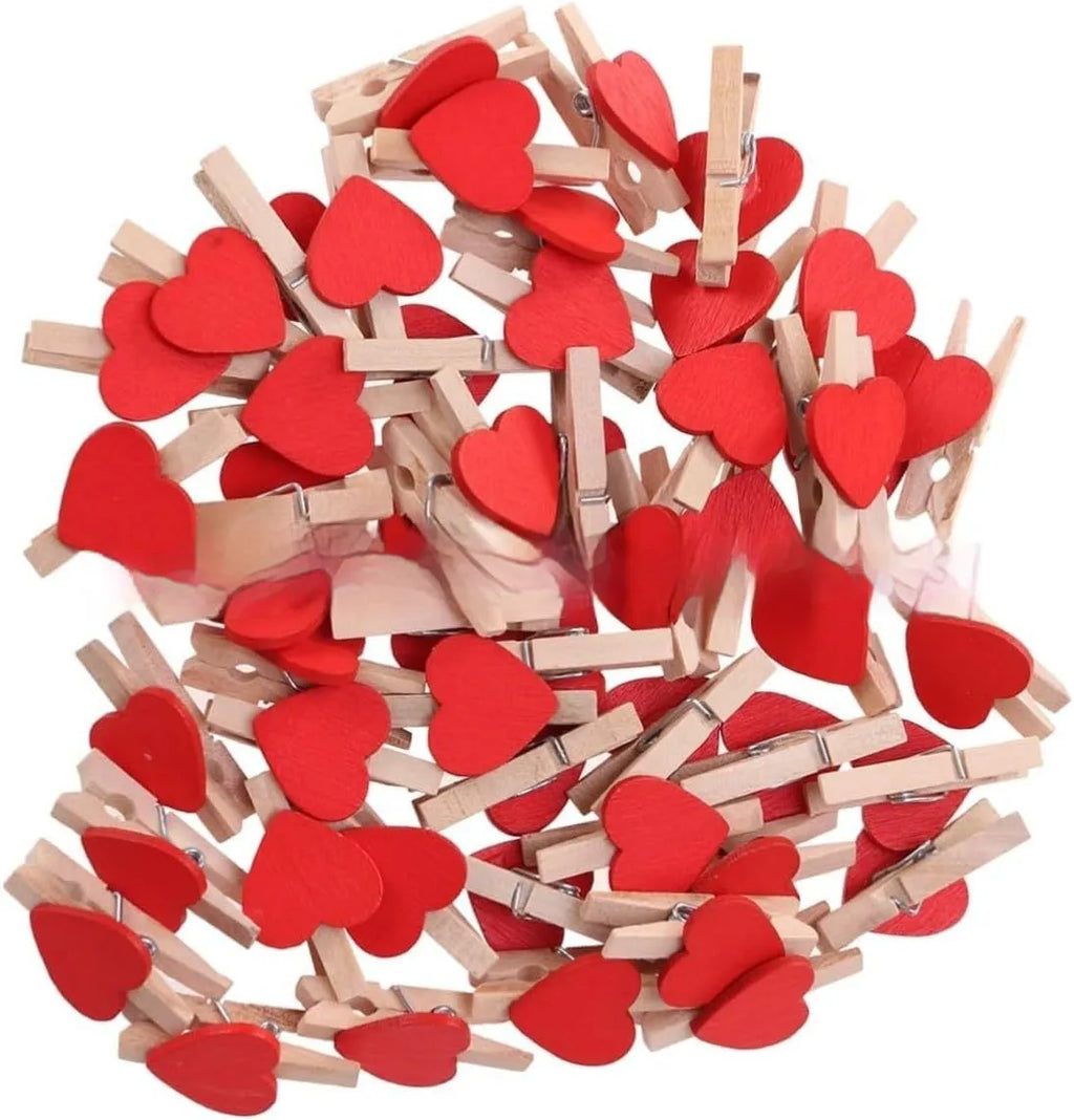 Five solid wood heart-shaped clips in red, rose red, and white colours on a natural background.