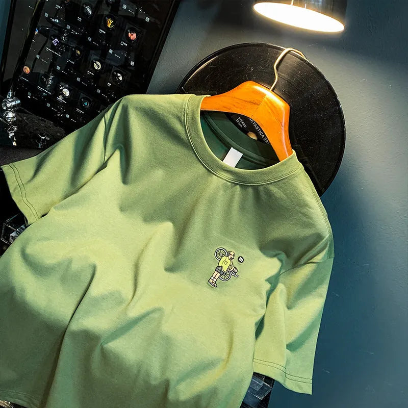 Green loose-fit men's t-shirt with a printed design on the front, featuring short sleeves.