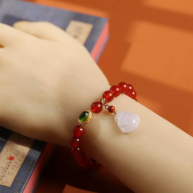 Handmade red agate and amber bracelet with geometric beads and a gold Maitreya Buddha charm.