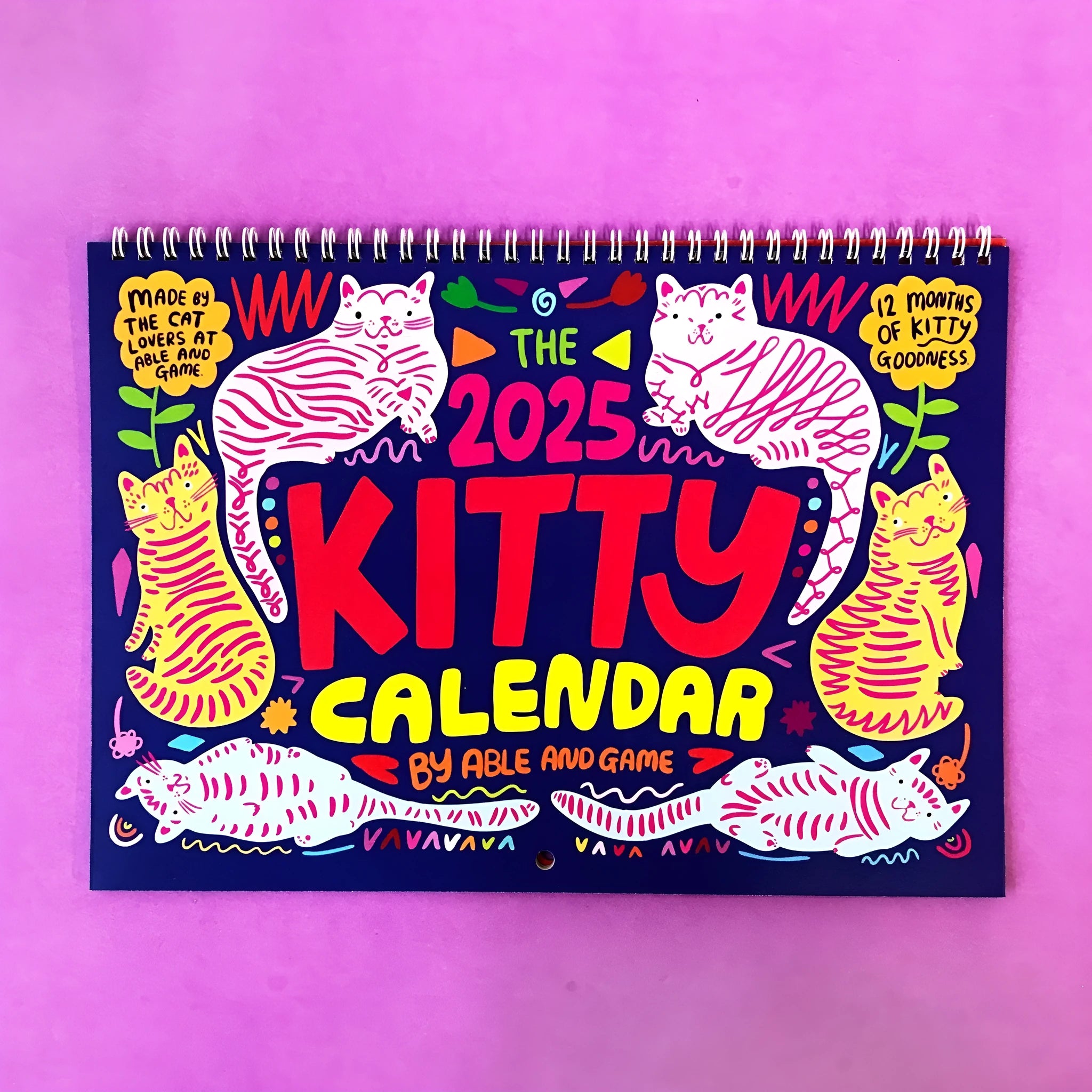 Cat themed wall calendar planner with daily tear-off sheets, showing photographic cat portraits and a clear date grid.