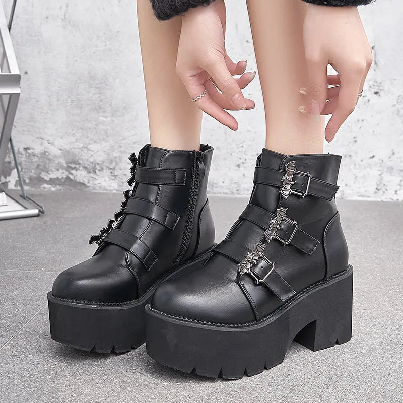Black women's punk ankle boots with bat buckle, side zipper, thick heel, and round toe.